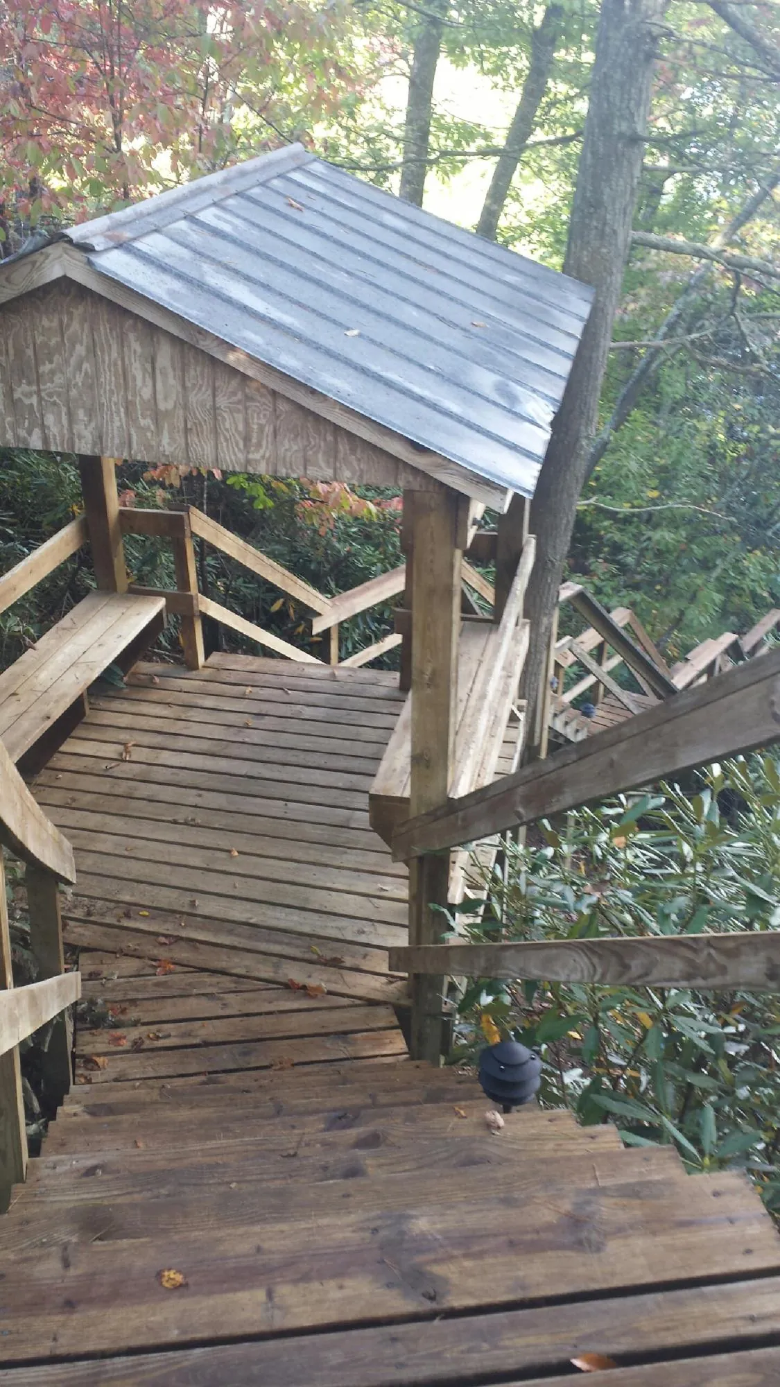 Metal roofed shelter over wooden steps on a wooded walkway — Skylight Repair & Installation work by our crew in Norwalk